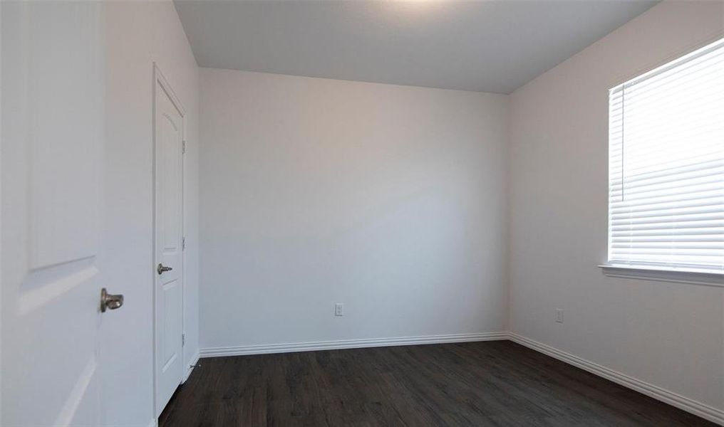 Empty room featuring dark hardwood / wood-style floors