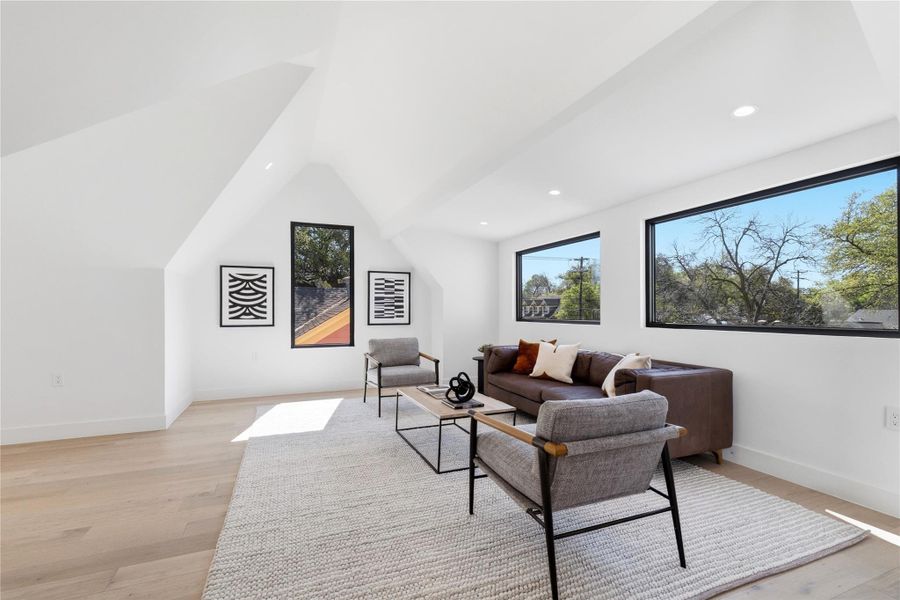 Living room with light wood-type flooring, lofted ceiling, and recessed lighting