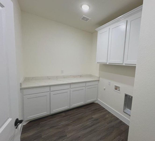 Washroom featuring washer hookup, dark hardwood / wood-style floors, and cabinets