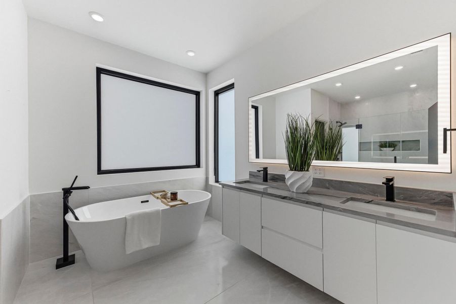 Bathroom with a stall shower, double vanity, a freestanding tub, recessed lighting, and light tile patterned floors