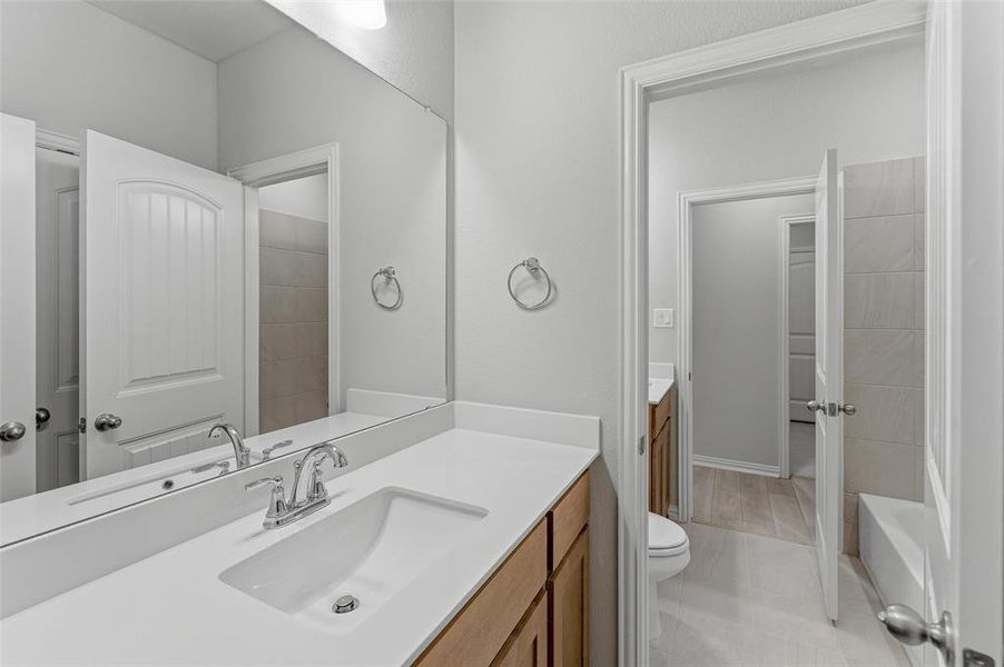 Bathroom vanity featuring a single integrated sink, chrome faucet, and expansive mirror