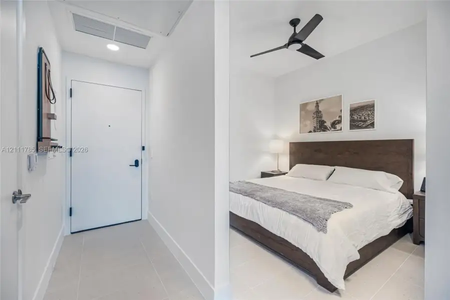 Entryway featuring a solid-core door with matte black hardware and large-format tile flooring