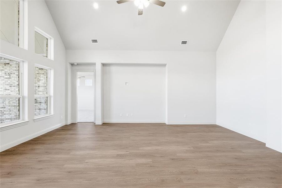 Unfurnished bedroom featuring light wood-style flooring, ceiling fan, high vaulted ceiling, and recessed lighting Unfurnished bedroom featuring light wood-style flooring, ceiling fan, high vaulted ceiling, and recessed lighting