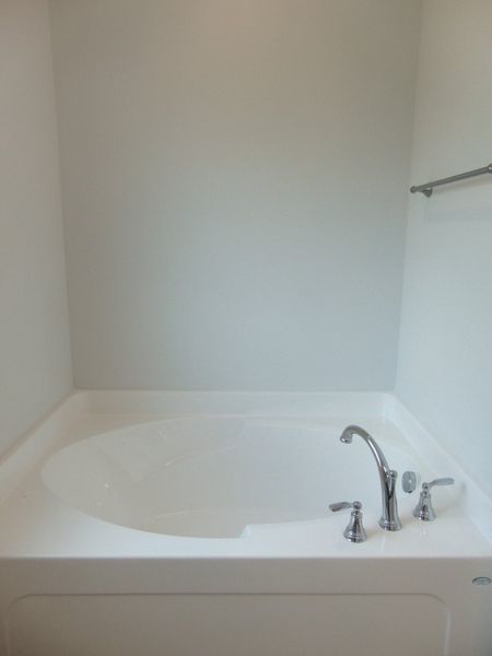The primary bathroom comes with a two sink, soaking bath tub, shower, and an elongated toilet.