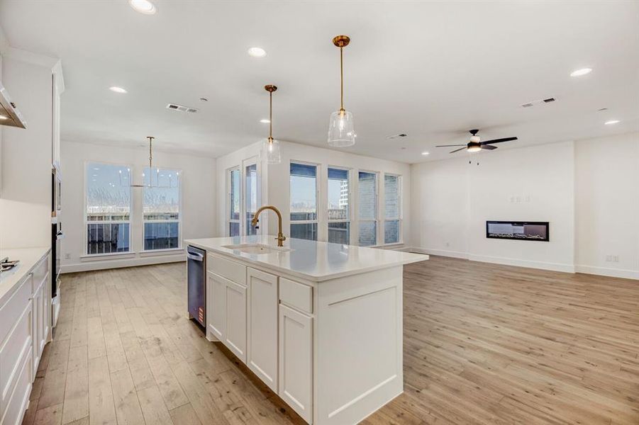 Kitchen with white cabinets, light wood-style flooring, and open floor plan