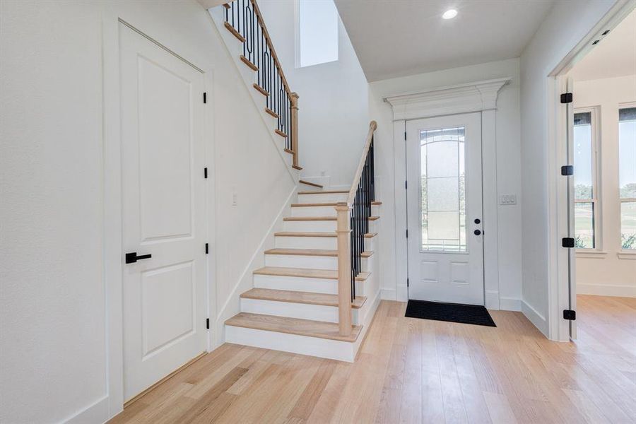 Light wood-finish flooring extending through the entry and into adjacent spaces Light wood-finish flooring extending through the entry and into adjacent spaces