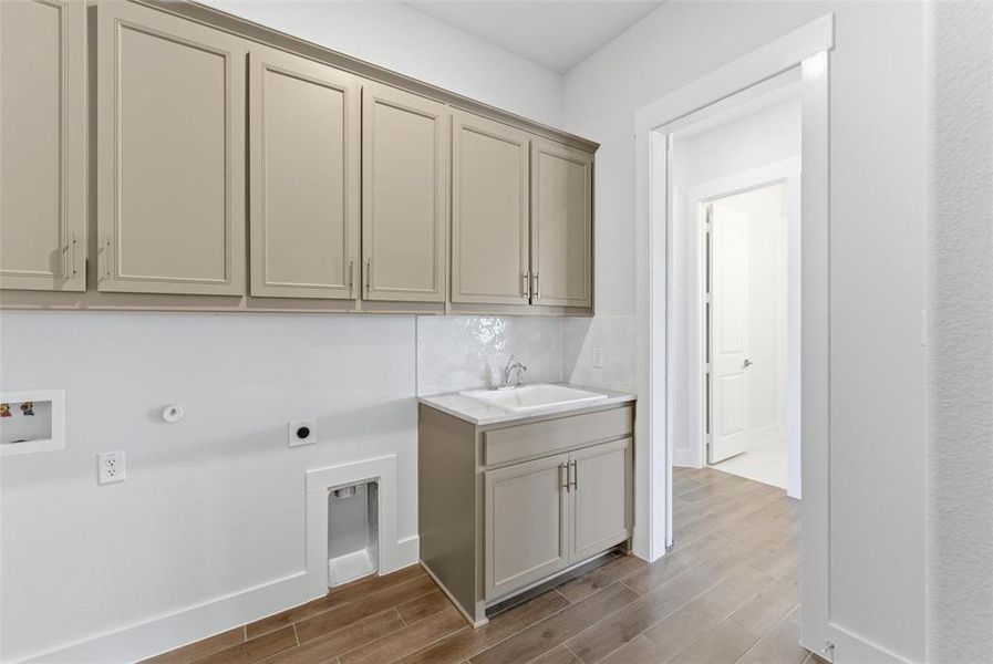 Laundry room with wood finish floors, gas dryer hookup, cabinet space, electric dryer hookup, and washer hookup