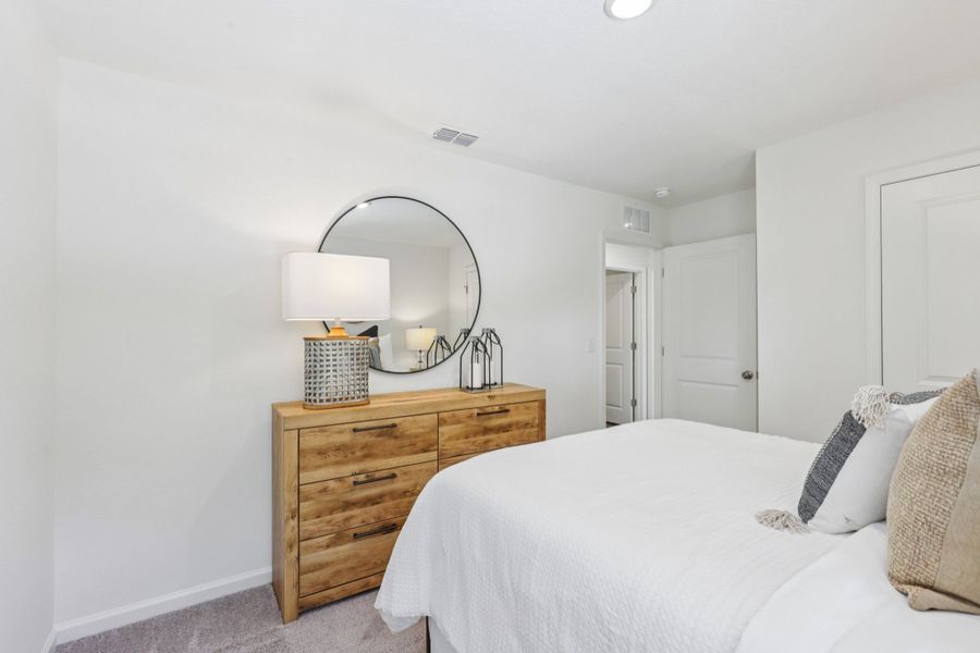 A bedroom with a mirror and a bed. A bedroom with a mirror and a bed.