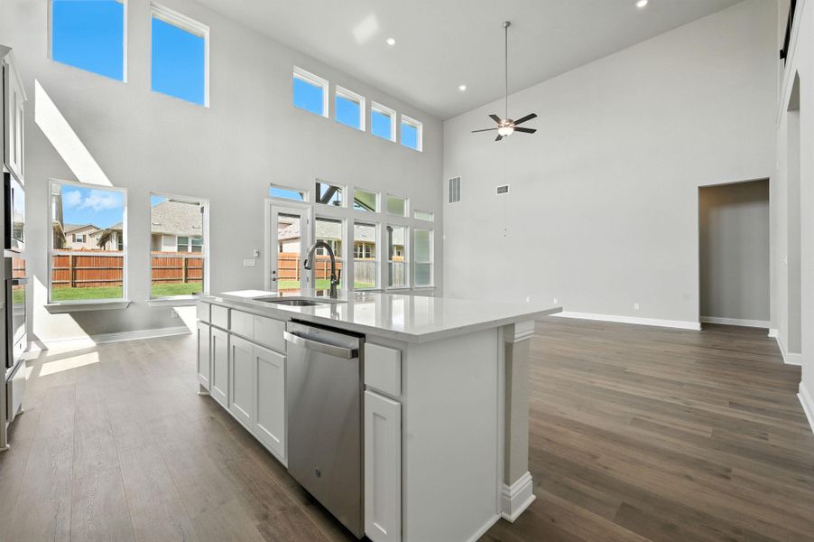 Kitchen with open floor plan, appliances with stainless steel finishes, white cabinets, dark wood-style flooring, and recessed lighting