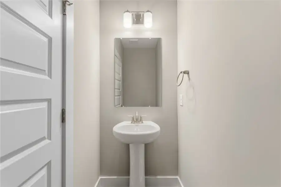 A classic pedestal sink sits beneath a modern vani A classic pedestal sink sits beneath a modern vani