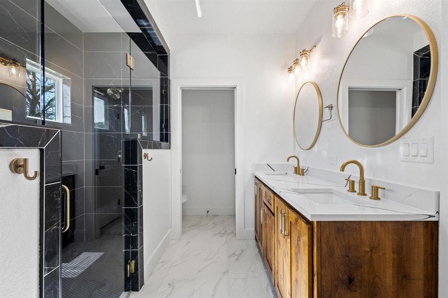 Bathroom featuring vanity, a shower with door, and toilet