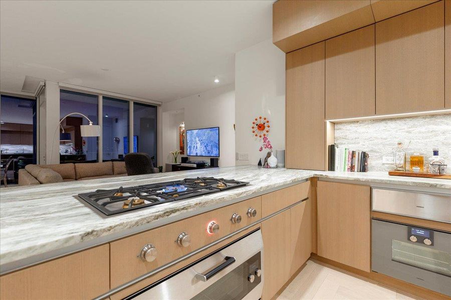 A chef-inspired workstation anchored by the Gaggenau; 5-burner gas cooktop and upgraded 36” oven with blue enamel interior, all set within 3cm Fantasy Brown marble countertops. The open connection to the living area makes it ideal for Omakase-style dinners, interactive cooking, and effortless entertaining.