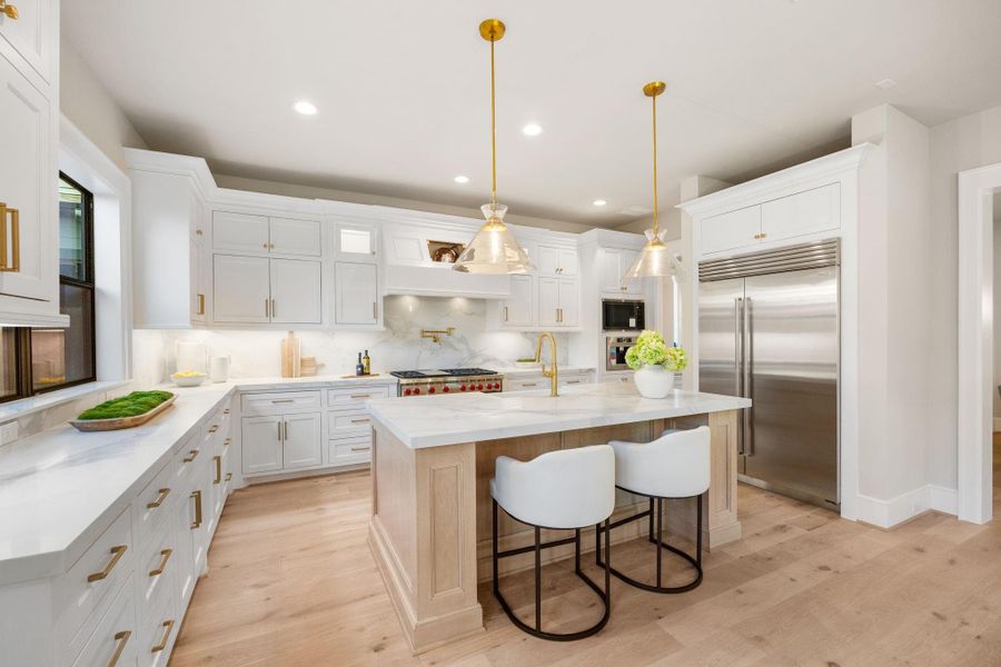 White Oak Floors & matching Island w/ quartz counters. 48in Thermador Fridge & Gas Range w/ pot-filler, built-in coffee maker Quartz slab backsplash.