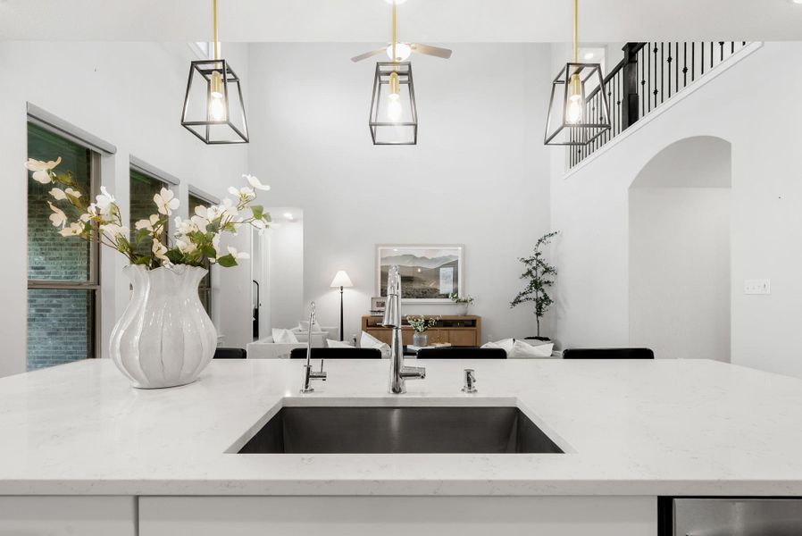 A spacious kitchen island with a gleaming sink anchors this light-filled, open-concept living space.