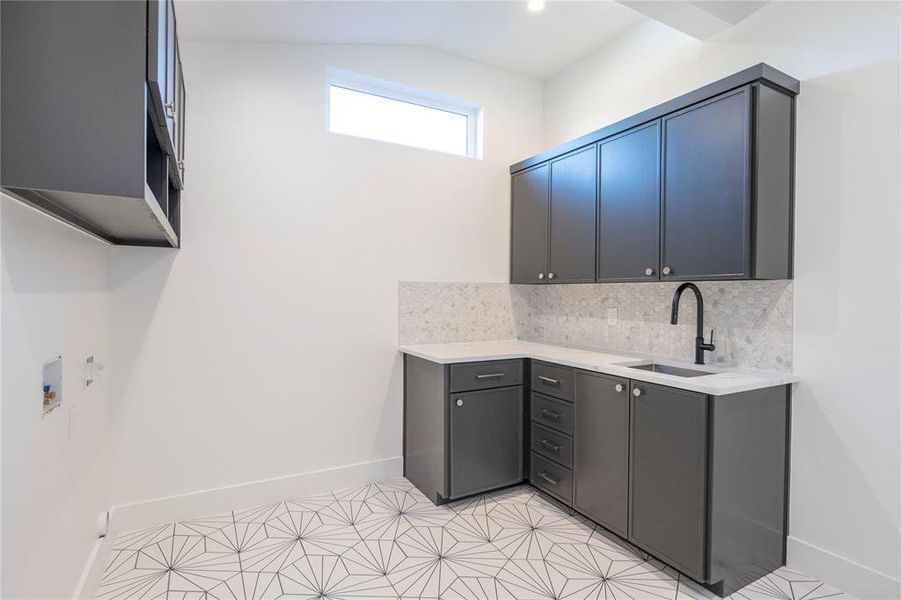 Kitchen featuring sink, backsplash, and light tile patterned floors