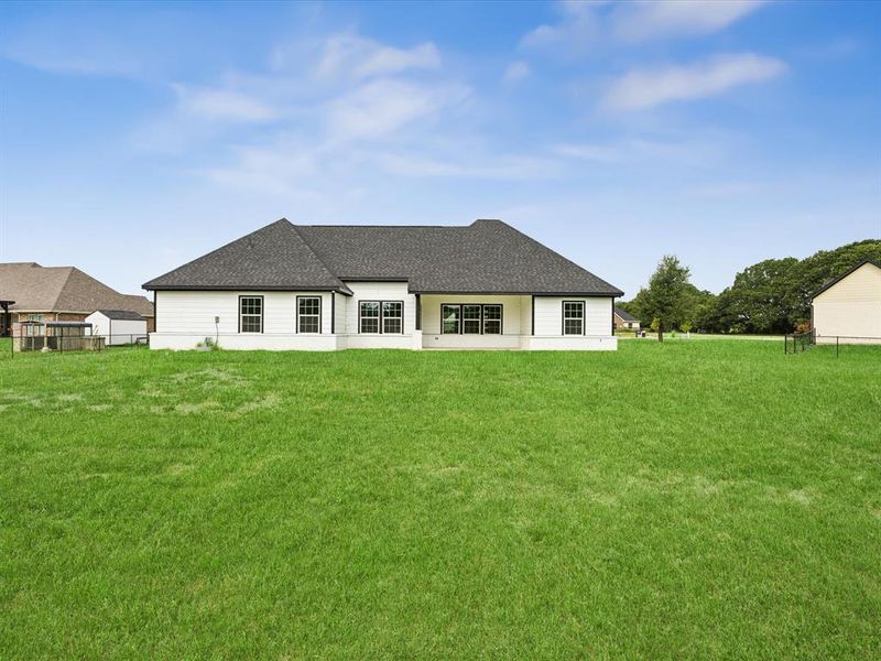 Rear view of property with a lawn