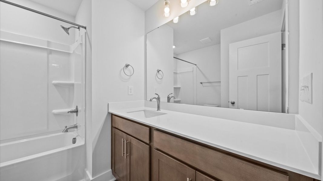 Wooden cabinetry bathroom in two story townhome at Ransdell Pointe by DRB Homes in Spartanburg, SC