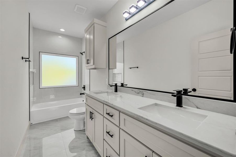 Bathroom with double vanity, shower / tub combination, light marble finish flooring, and recessed lighting