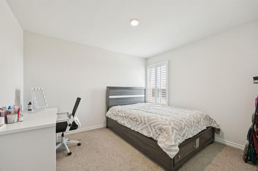 Bedroom with light carpet and an office area