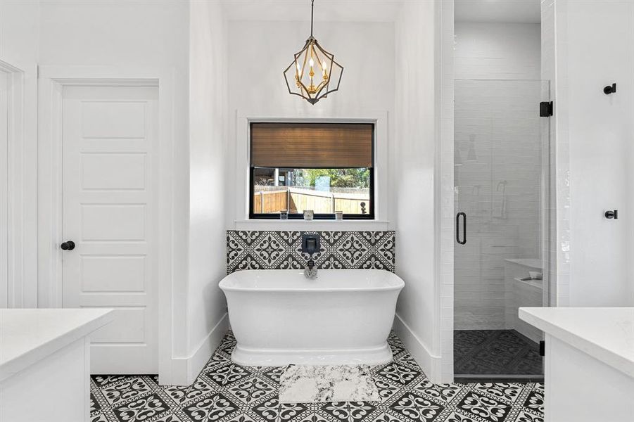 Full bath featuring a soaking tub, tile patterned floors, a stall shower, baseboards, and a chandelier Full bath featuring a soaking tub, tile patterned floors, a stall shower, baseboards, and a chandelier
