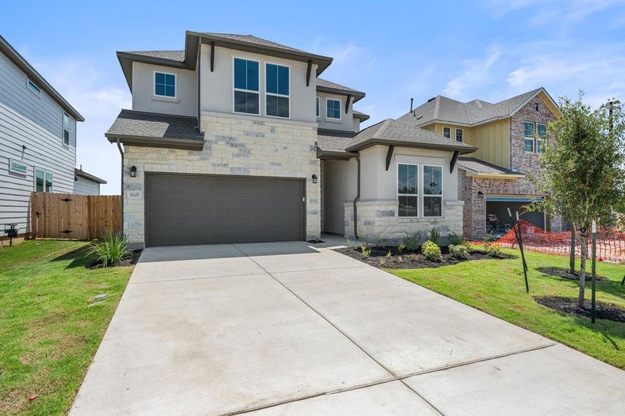 Front exterior of a new home in Lagos Reserve, Manor, TX, highlighting curb appeal (Image 21). Front exterior of a new home in Lagos Reserve, Manor, TX, highlighting curb appeal (Image 21).