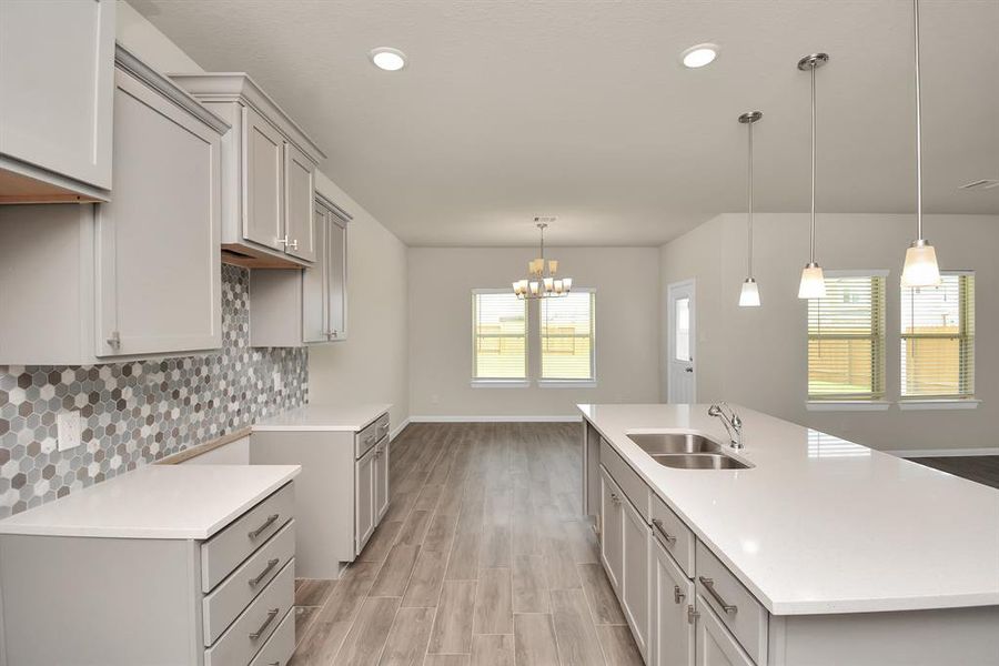 Dinner parties made easy. This open-concept kitchen transitions into a dedicated dining area. **This image is from another Saratoga Home with similar floor plan and finishes, not the Brittany floorplan.**