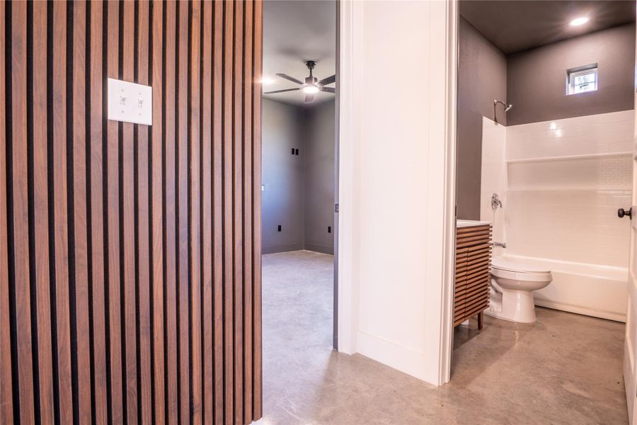 Bathroom with concrete floors, a ceiling fan, bathing tub / shower combination, and vanity