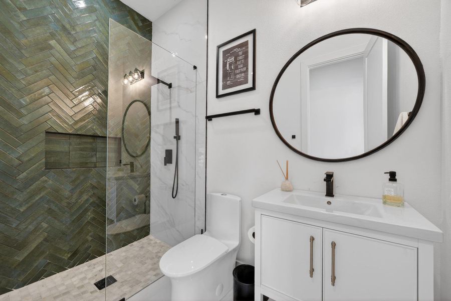 Bathroom with vanity and a marble finish shower