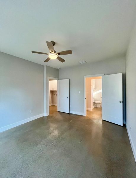 Unfurnished bedroom featuring concrete floors and ceiling fan