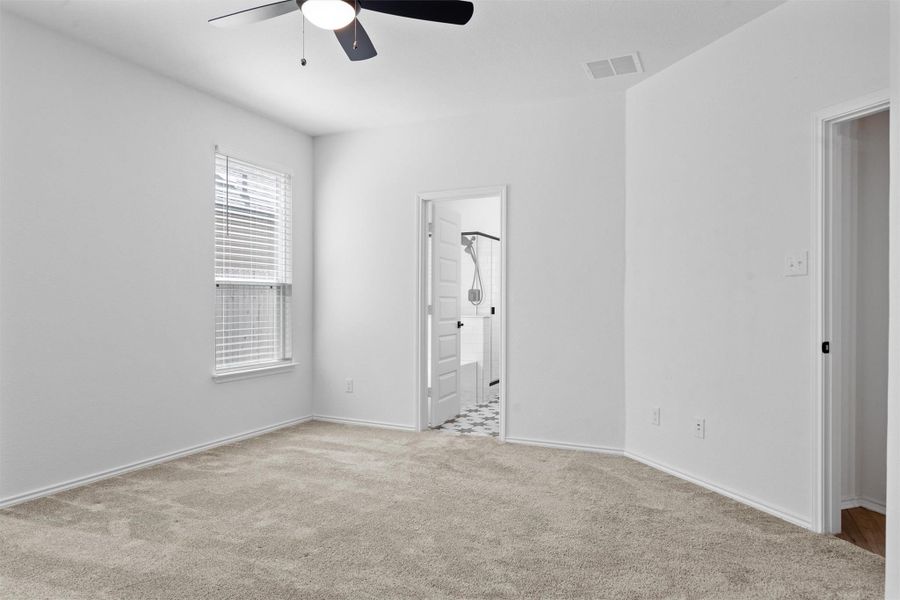 Unfurnished bedroom featuring carpet floors, a ceiling fan, and connected bathroom
