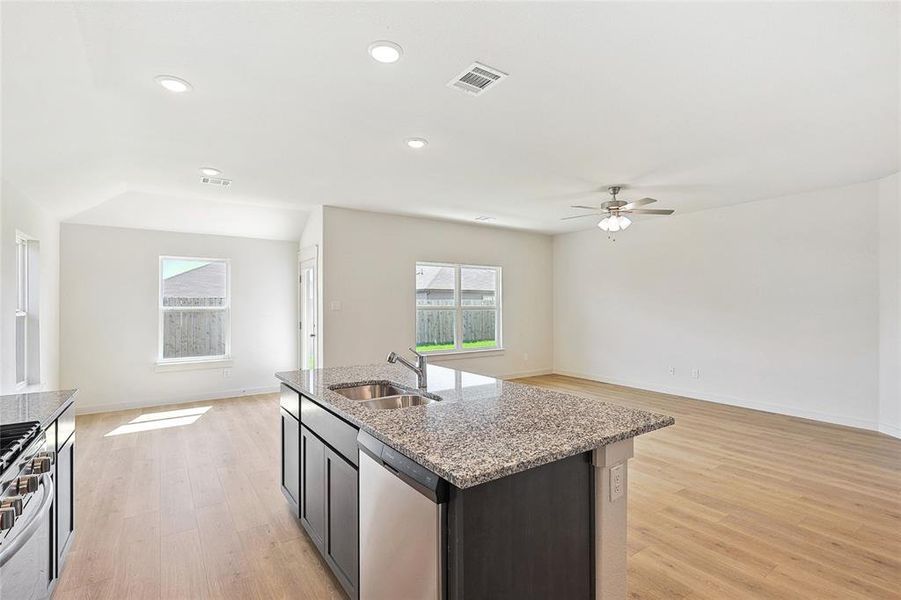 Kitchen featuring ceiling fan, an island with sink, sink, stainless steel appliances, and light hardwood / wood-style floors