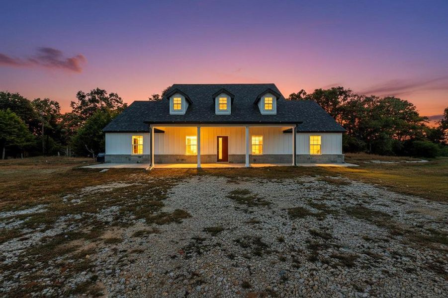 View of front of home with covered porch, board and batten siding, a shingled roof, and crawl space