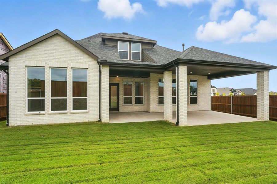 Back of house featuring a patio, a shingled roof, and brick siding Back of house featuring a patio, a shingled roof, and brick siding
