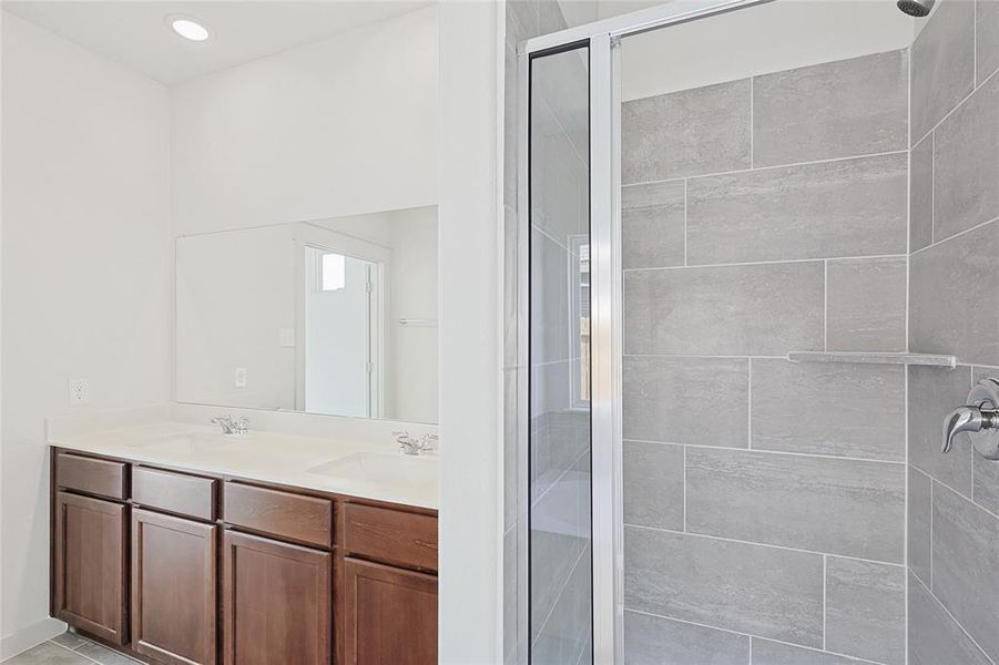 Bathroom featuring vanity and a shower with shower door