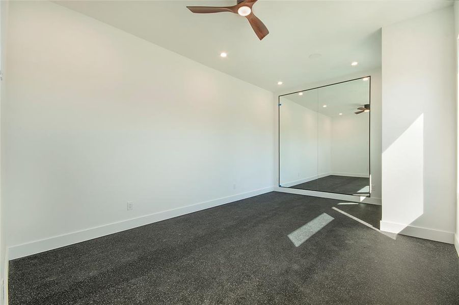 Unfurnished room with a ceiling fan, recessed lighting, and dark carpet