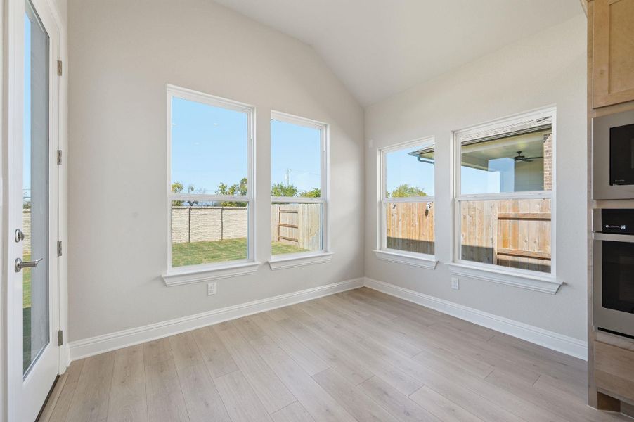 Unfurnished sunroom featuring lofted ceiling and wood finished floors Unfurnished sunroom featuring lofted ceiling and wood finished floors