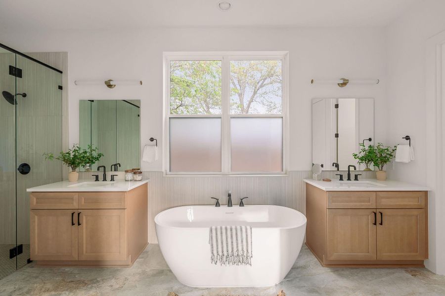 Bathroom with wainscoting, a shower stall, a freestanding bath, and two vanities Bathroom with wainscoting, a shower stall, a freestanding bath, and two vanities