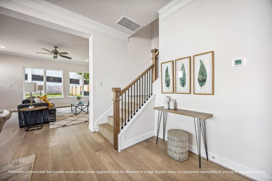 Elegant Transition: This beautifully crafted staircase, with warm wood tones and sleek iron balusters, leads to the versatile second floor featuring a game room and private office space—perfect for work and play.