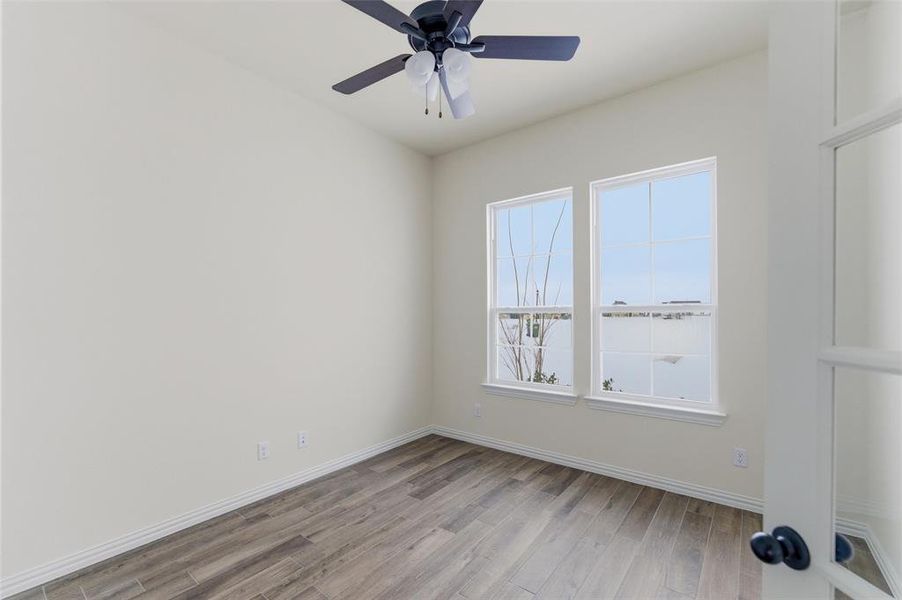 Empty room featuring light wood-style floors and a ceiling fan