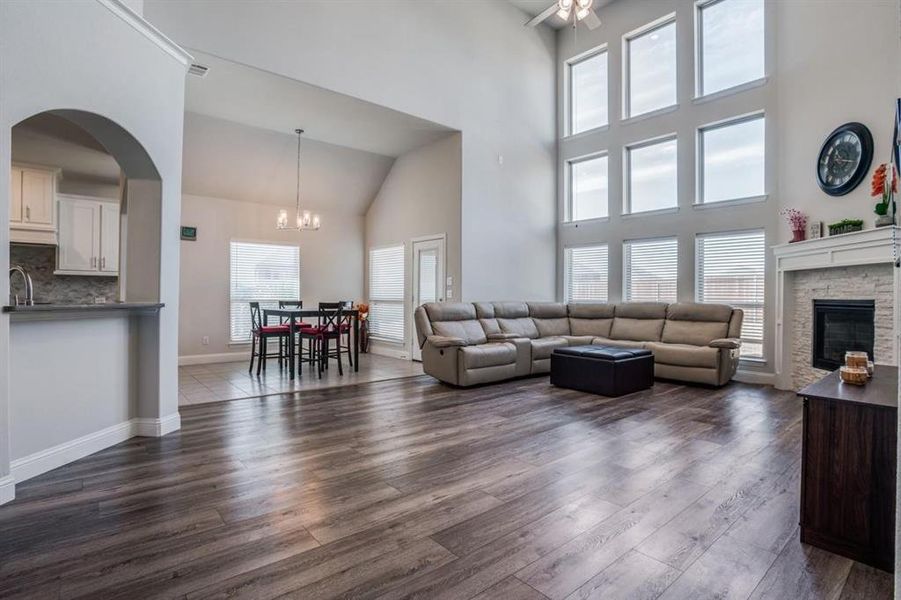 Living room with dark hardwood / wood-style floors, a healthy amount of sunlight, and high vaulted ceiling