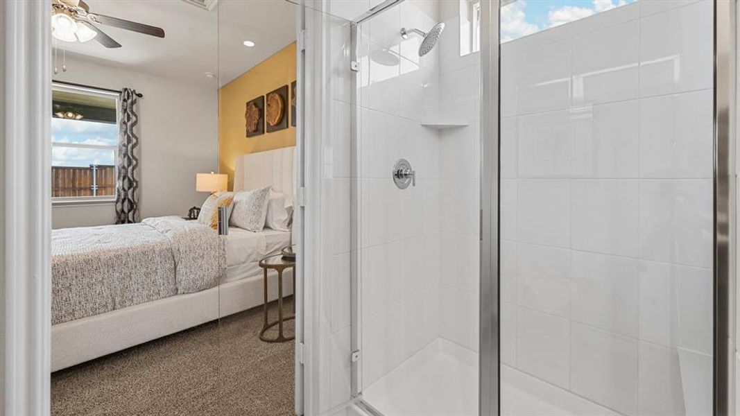 Bathroom featuring connected bathroom, ceiling fan, a stall shower, and carpet flooring Bathroom featuring connected bathroom, ceiling fan, a stall shower, and carpet flooring