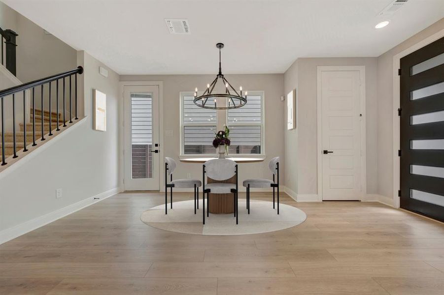 Dining area with light wood finished floors and a chandelier