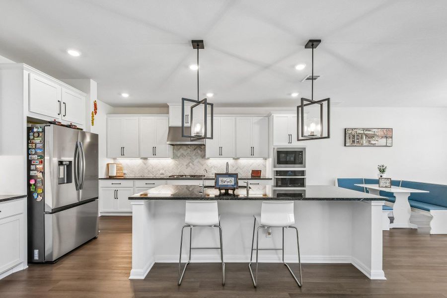 Bright, open kitchen with abundant white cabinetry, a spacious island, and built-in appliances perfect for culinary pursuits.