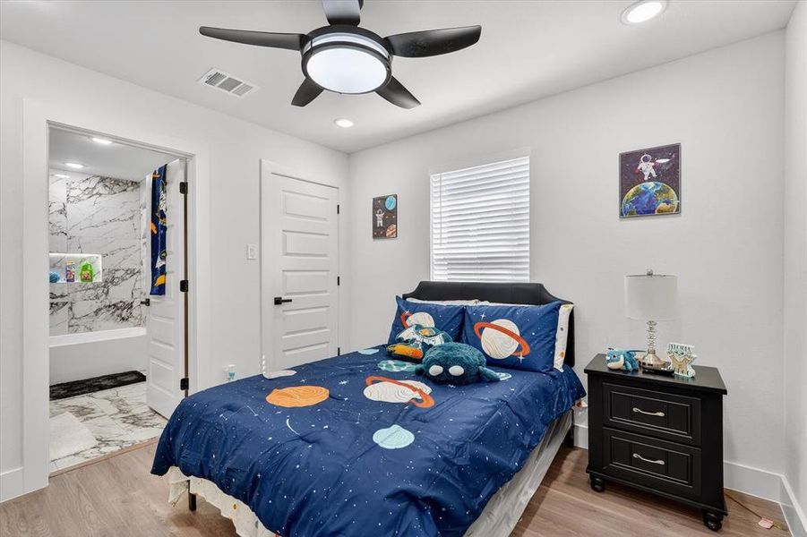 Bedroom featuring wood-finish flooring, recessed lighting, and a modern ceiling fan with integrated lighting
