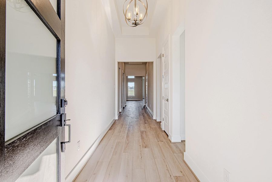 Entry hallway featuring wood flooring and a clear sightline into main living areas.