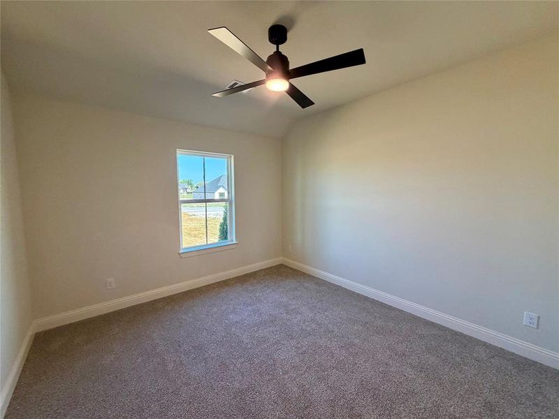 Empty room with carpet, a ceiling fan, and vaulted ceiling Empty room with carpet, a ceiling fan, and vaulted ceiling