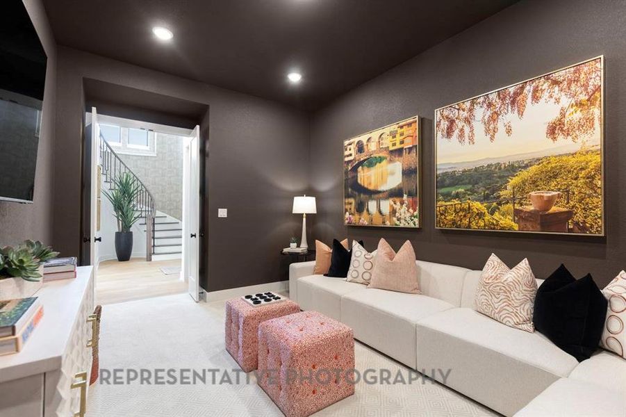 Carpeted living room featuring stairs and recessed lighting Carpeted living room featuring stairs and recessed lighting