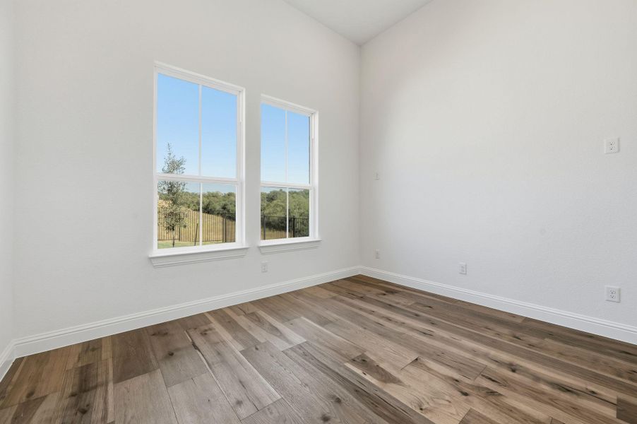 Unfurnished room with wood finished floors and baseboards