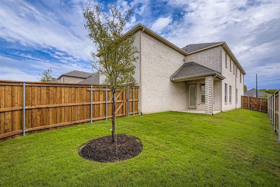 Back of house with brick siding, a fenced backyard, a patio, and roof with shingles Back of house with brick siding, a fenced backyard, a patio, and roof with shingles