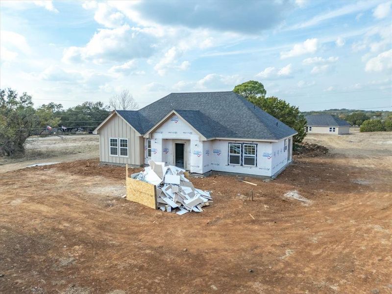 Property under construction featuring roof with shingles and board and batten siding